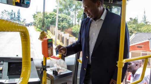 Male Black Commuter entering bus using Tap & Go payment system
