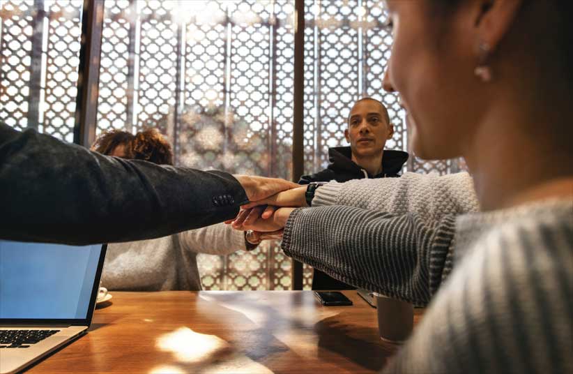 Picture of people in board room joining hands